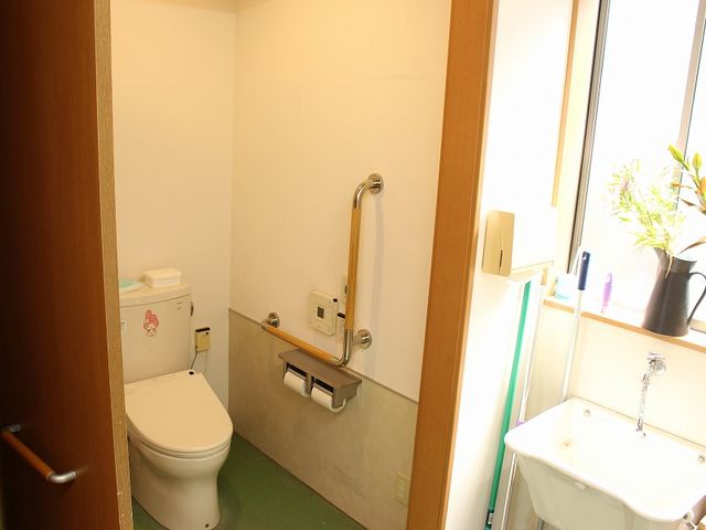 手すり付きのトイレ トイレ 自然光が差し込む清潔なトイレです。手すりが設置されており、安全に配慮されています。