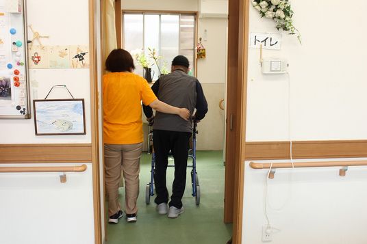 介助を受ける人と職員がいる廊下