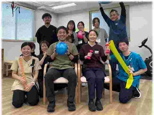 運動するスタッフ集団の多目的室  