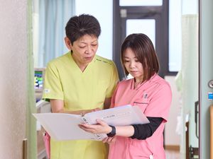 スタッフが書類確認する廊下  