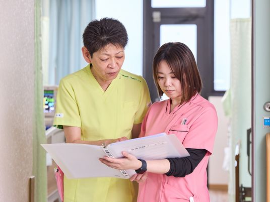 スタッフが書類確認する廊下  