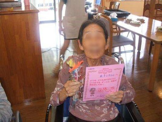 賞状を持つ高齢者