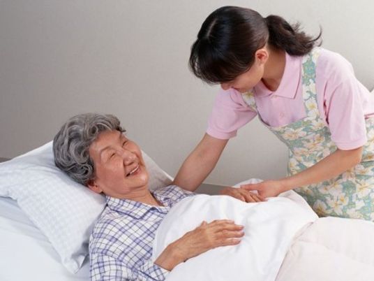 介護者と寝ている高齢者