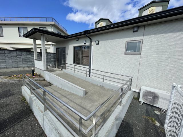入り口にあるスロープ エントランス 建物の出入り口にはスロープが設置されており、車椅子でもアクセスがしやすくなっています。