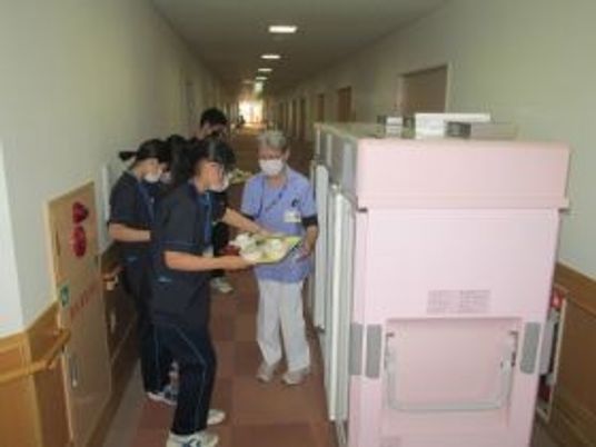 廊下で利用者を支える職員  