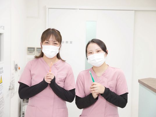 笑顔のスタッフ二人と洗面台  