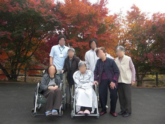 秋の中庭で利用者たち