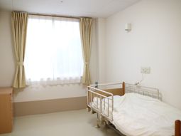 明るい居室のベッドと窓