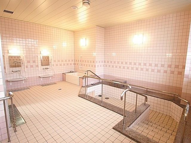 広い浴室の洗い場 浴室   明るいタイル張りの浴室で、洗い場が広く取られています。手すりもあり、動線を確保しやすい印象です。