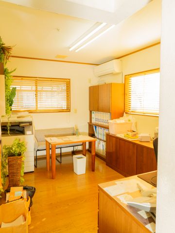 暖かい雰囲気の休憩室 談話スペース 窓からの自然光が心地よい休憩室です。木のテーブルが、落ち着いた時間を過ごす場を演出しています。