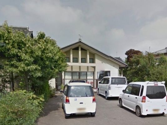 施設前の車と建物