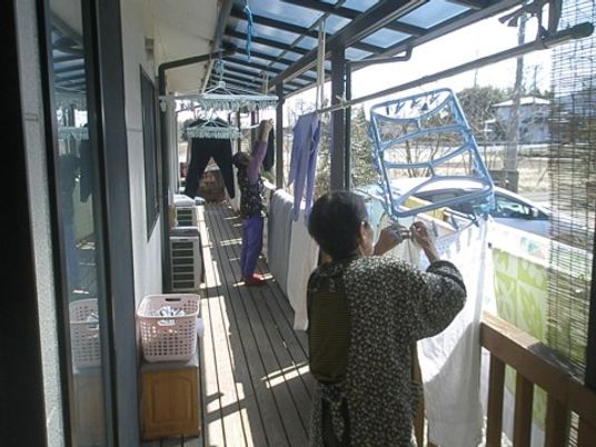 バルコニーで洗濯物を干す人