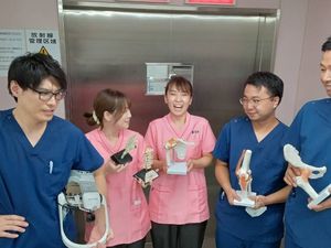 医療スタッフが模型を持つ廊下  