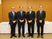 スーツ姿の男性4人が並ぶ会議室  