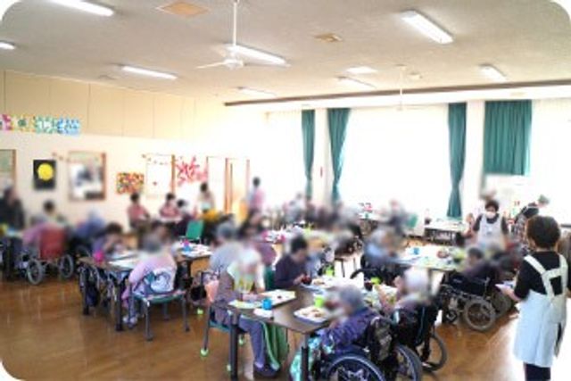 活気ある室内 ダイニングルーム 広々とした明るいスペースで、多くの人が楽しく交流しています。
