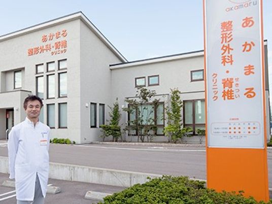 男性スタッフと建物外観  
