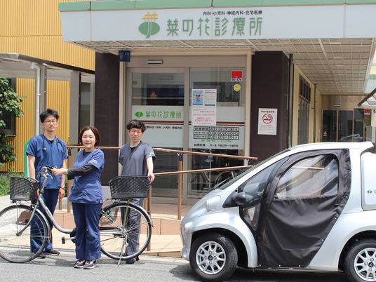 スタッフが並ぶ施設の外観  