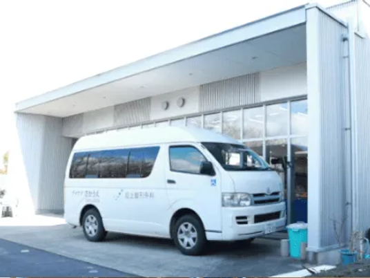 送迎車が停まる玄関外観  