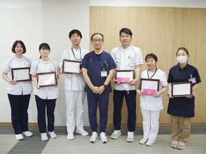 表彰状を持つ職員の集合