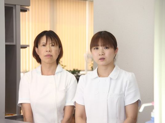 白衣の職員が並ぶ受付  