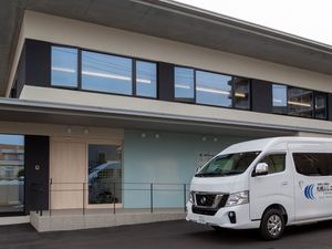 送迎車が停まる施設外観  