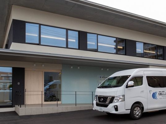 送迎車が停まる施設外観  