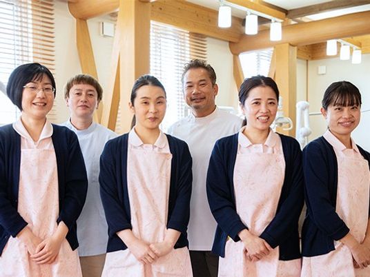 スタッフが並ぶ明るい食堂  