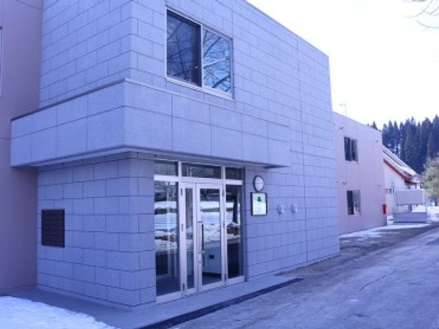 施設外観の建物 外観   グレーの外壁が印象的な建物です。出入口はガラス扉で、明るく落ち着いた雰囲気が感じられます。