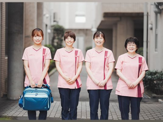 笑顔の職員が並ぶ外観  