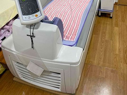 ベッド脇の洗面台と木目床の居室  