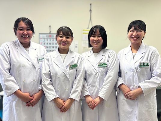 白衣のスタッフが並ぶ休憩室  