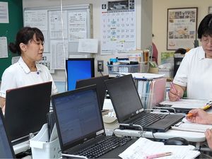 スタッフが会議する事務室  