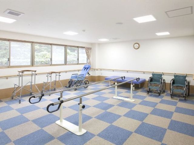 リハビリ器具が整う部屋 リハビリルーム ゆとりある空間でのリハビリをサポートする設備が整っています。体を動かしながら健康維持に努めることができる環境です。