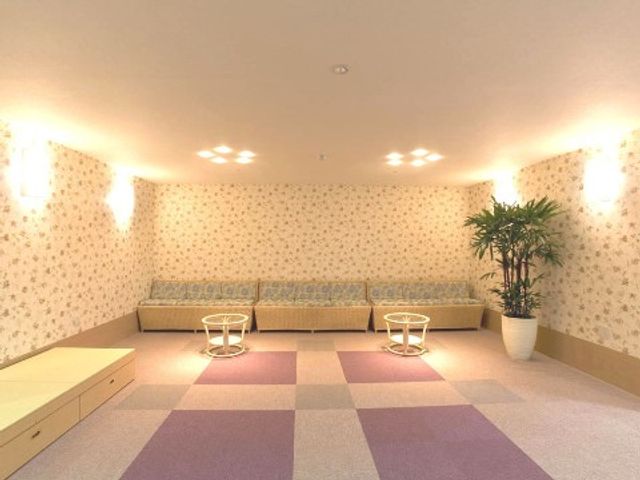落ち着きのある休憩室 湯上がり室 温かみのある照明と柄壁紙が特徴の休憩スペースです。清潔感のある空間で息抜きをされている様子が伝わります。