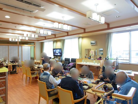 居室で食事する人々 