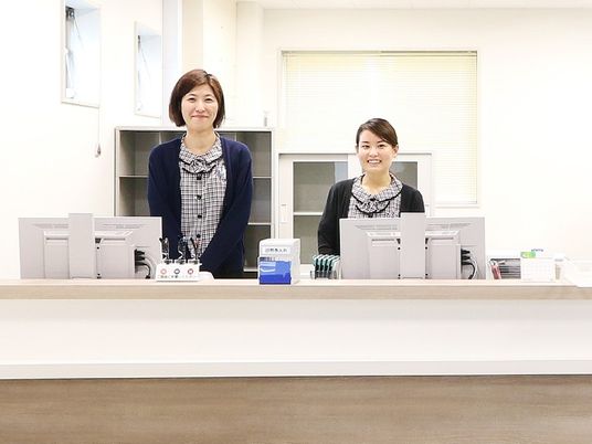 受付で笑顔のスタッフ2人  
