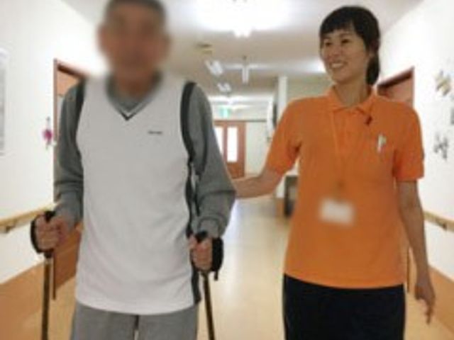 笑顔のスタッフと加療者の廊下 廊下 笑顔のスタッフが加療者と一緒に廊下を歩いています。温かなサポート体制が魅力です。