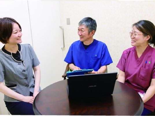 スタッフ3人の対話がある会議室  