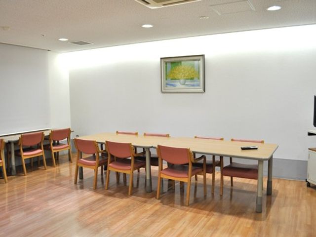 明るい食堂のテーブル 食堂   木目調の床と大きなテーブルが並ぶ、すっきりした食堂です。壁際にも席があり、落ち着いて過ごしやすそうです。