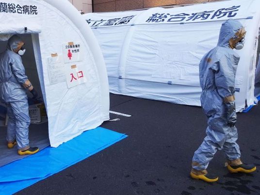 防護服の職員がいる入口前  