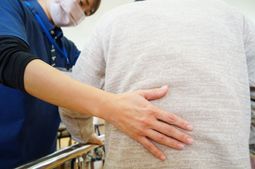 スタッフが背中を支える様子