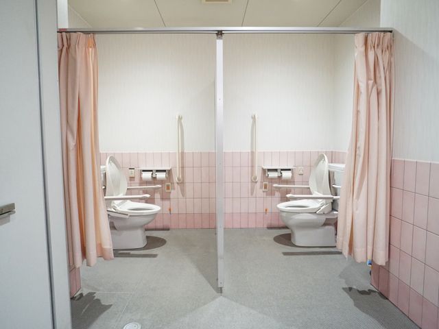 バリアフリートイレ設備 トイレ 手すり付きで安全性に配慮したトイレ空間です。個室にはプライバシーを守るカーテンが設置されており、安心してご利用いただけます。
