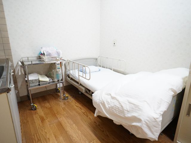 清潔な個室の居室 診断室 整えられた居室は、暖かみのあるフローリングが特徴で、くつろぎやすい空間を提供しています。必要な物品を整理しやすい収納も完備されております。