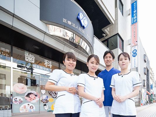 医療法人の外観前のスタッフ  