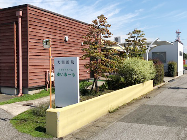 「看板」前の施設外観 外観 建物の外観は、自然を感じることができる設計で、落ち着いた雰囲気を提供します。