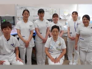 白衣のスタッフが並ぶ休憩室  