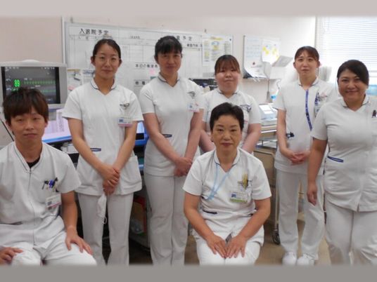 白衣のスタッフが並ぶ休憩室  