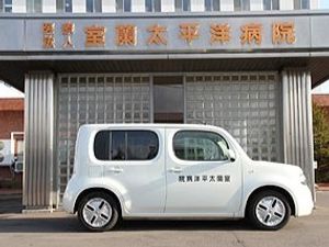 施設前の送迎車と看板  