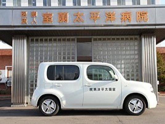施設前の送迎車と看板  