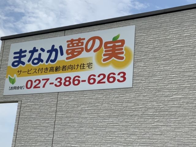 サービス付き高齢者向け住宅外観 看板 「まなか夢の実」のサービスを提供する施設の案内看板が設置されています。